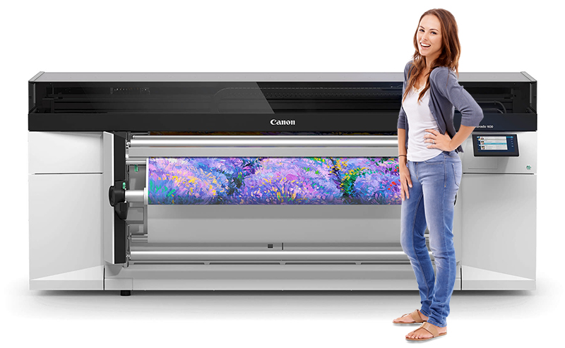 Woman next to a large printer printing out a picture of flowers